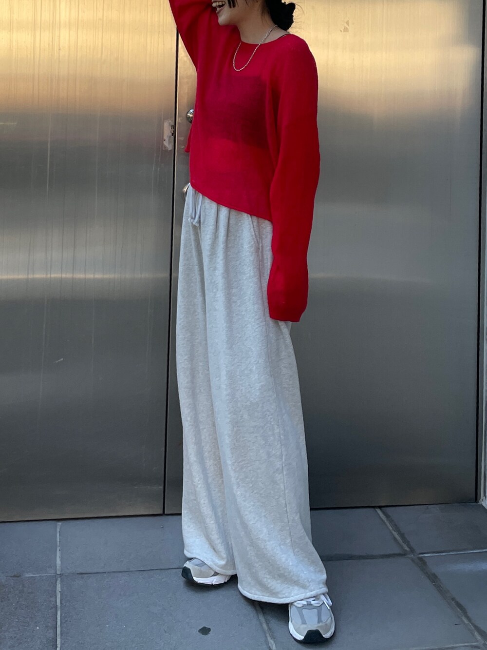 グレー系のスウェットパンツ、レッド系のニット/セーターを着用したレディースの秋コーディネートの3枚目の写真