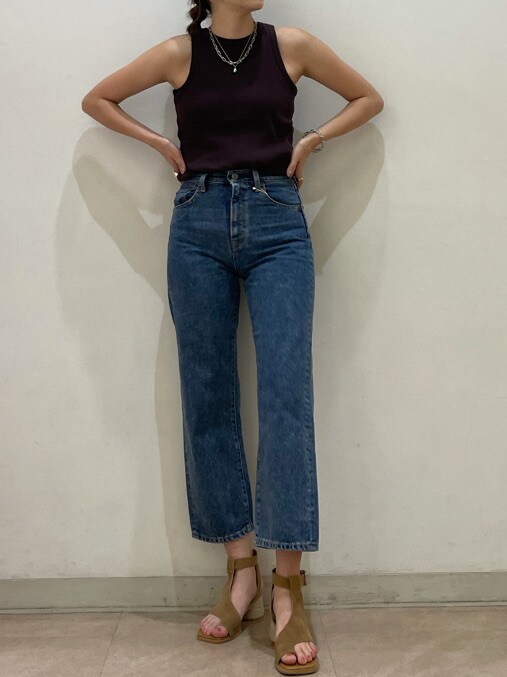 ブラウン系のサンダル、ブルー系のデニムパンツを着用したレディースの春コーディネートの3枚目の写真