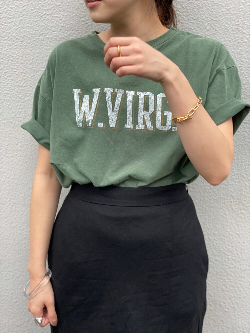 ブラック系のスカート、ブラック系のサンダル、グリーン系のTシャツ/カットソーを着用したレディースの春コーディネートの3枚目の写真