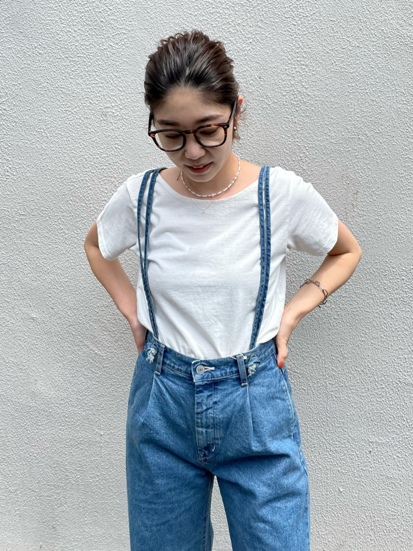 ブルー系のデニムパンツ、ホワイト系のTシャツ/カットソー、オレンジ系のサンダルを着用したレディースの夏コーディネートの2枚目の写真