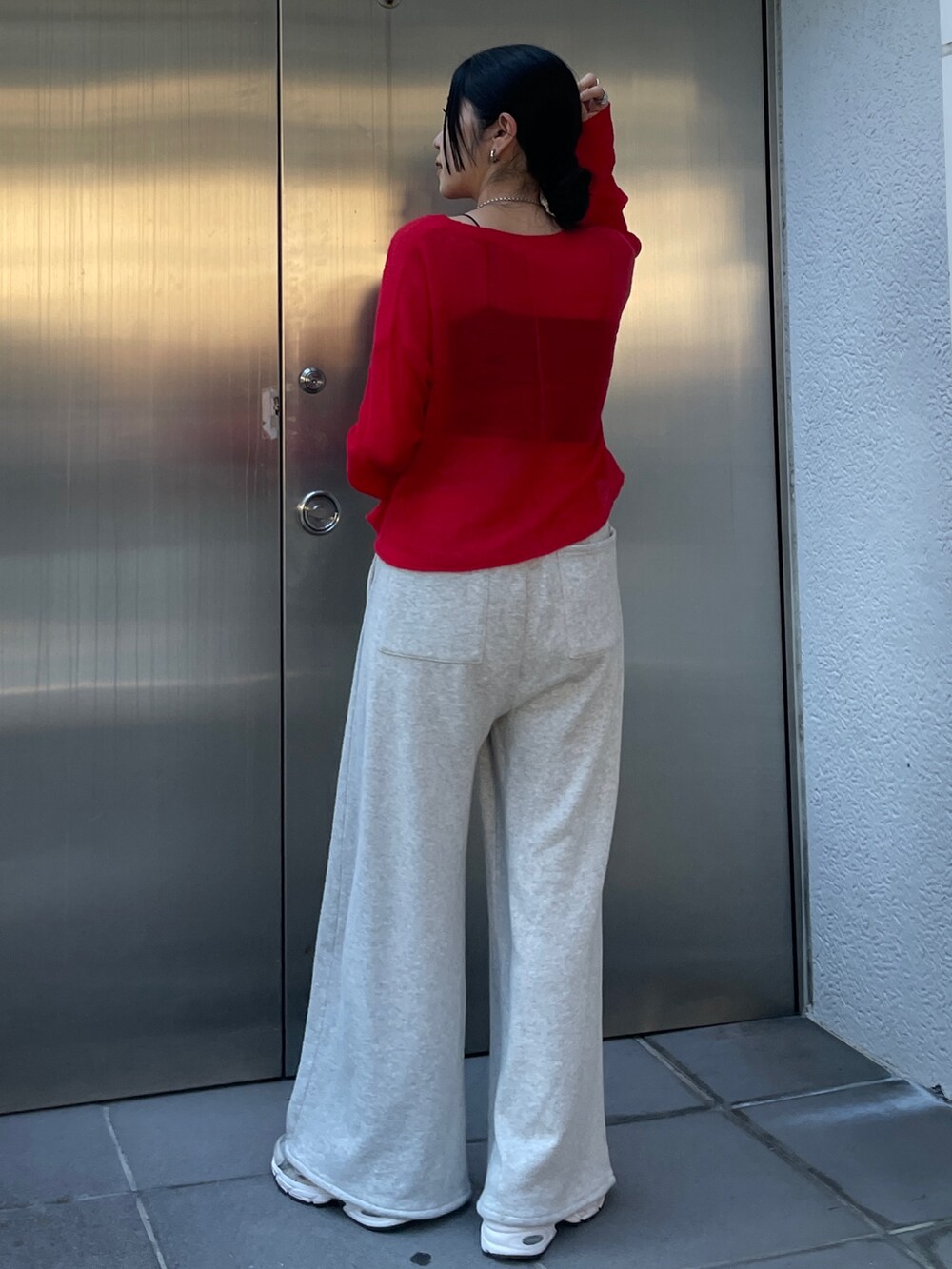 グレー系のスウェットパンツ、レッド系のニット/セーターを着用したレディースの秋コーディネートの2枚目の写真