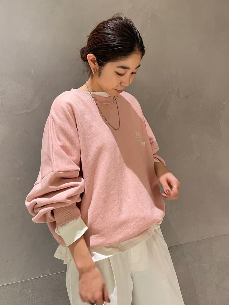 ホワイト系のスラックス、ピンク系のスウェット、ピンク系のスニーカーを着用したレディースの冬コーディネートの2枚目の写真