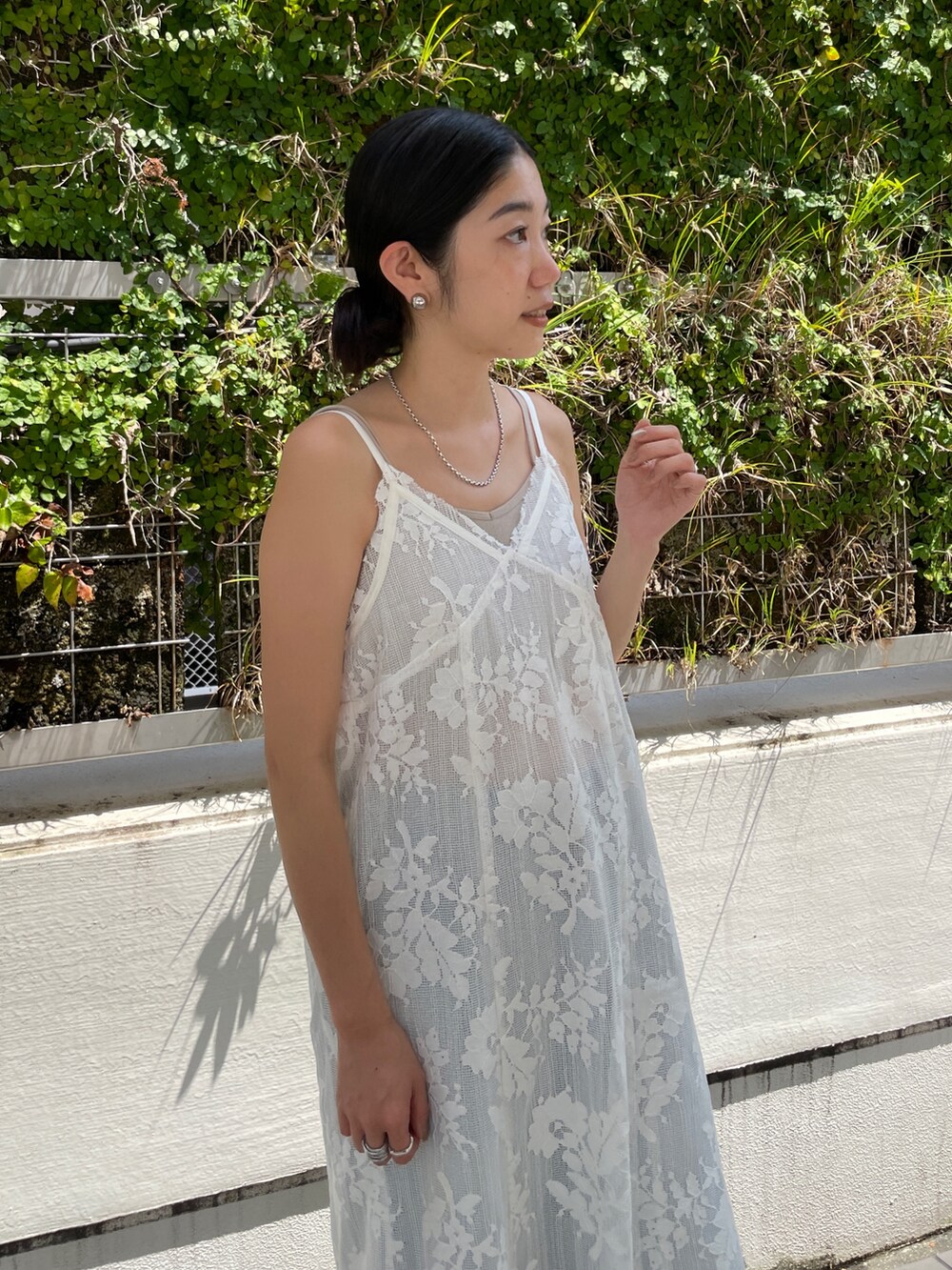 ホワイト系のワンピース、グレー系のキャミソール、ブルー系のデニムパンツを着用したレディースの夏コーディネートの4枚目の写真