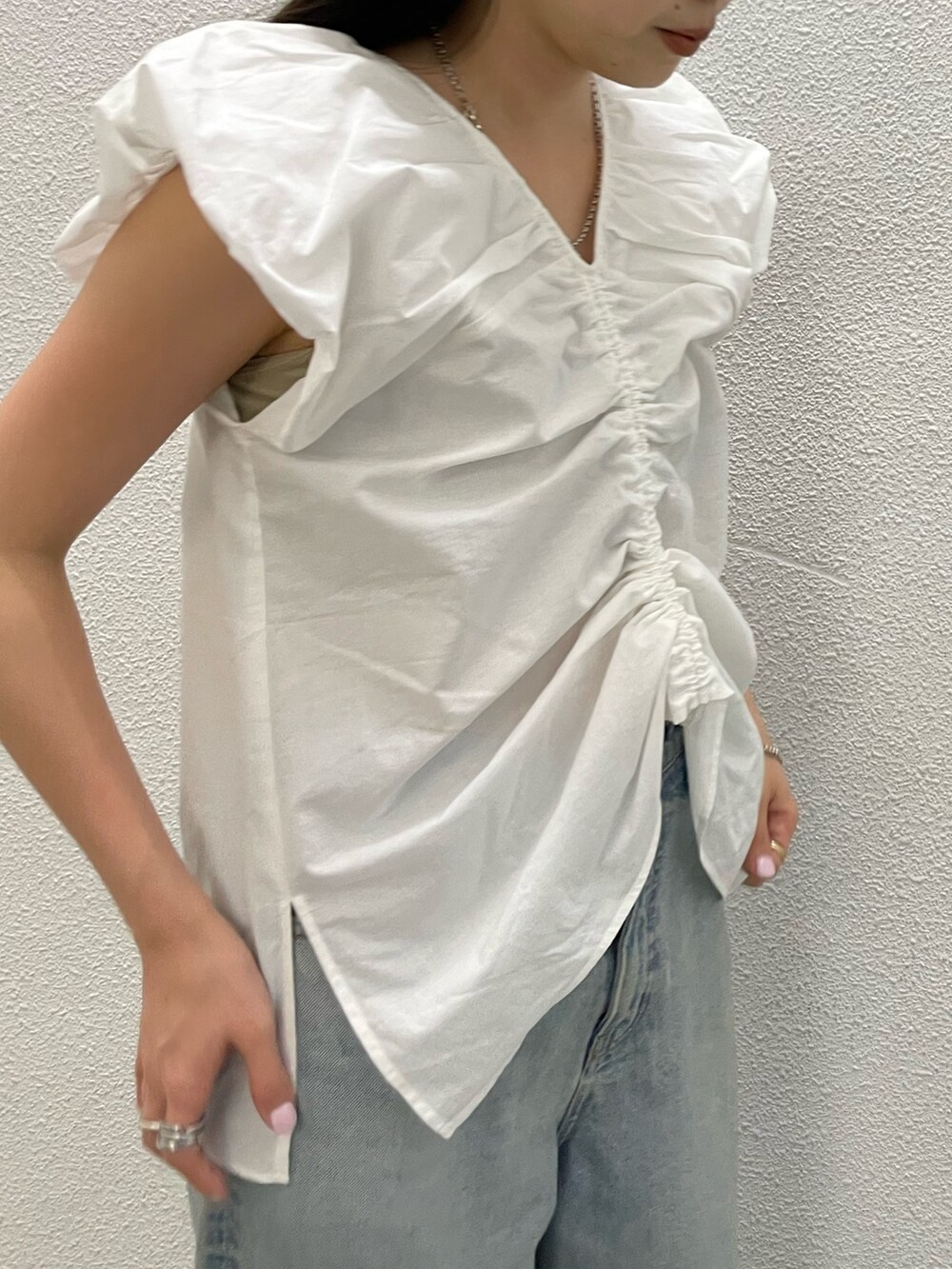 ホワイト系のシャツ/ブラウス、ブルー系のデニムパンツ、シルバー系のサンダルを着用したレディースの春コーディネートの5枚目の写真