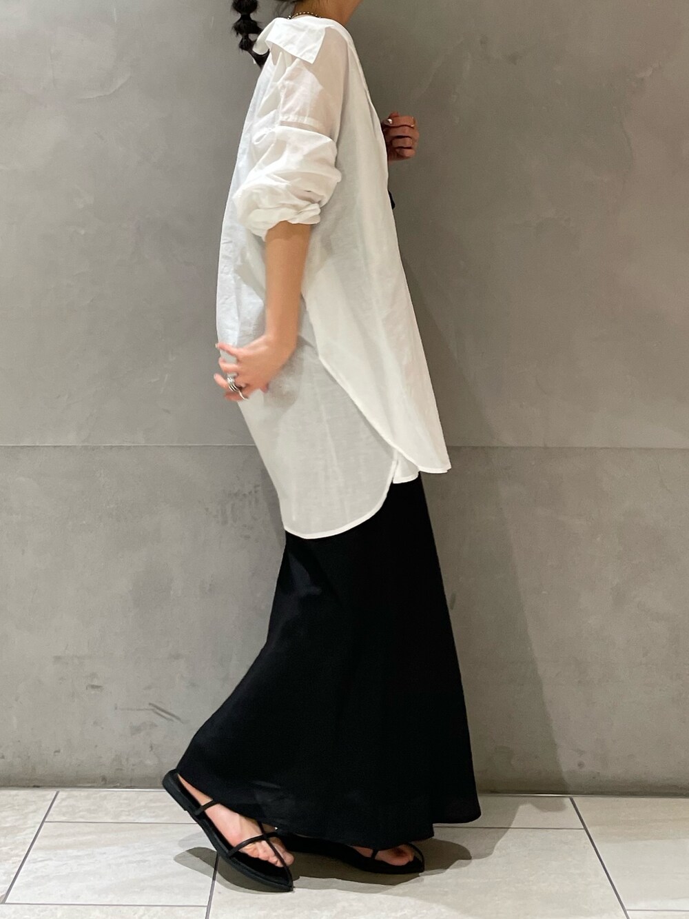 ブラック系のスカート、ホワイト系のシャツ/ブラウス、ブラック系のサンダルを着用したレディースの春コーディネートの6枚目の写真