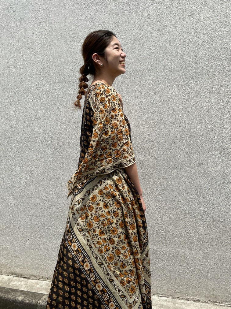 ブラック系のサンダル、イエロー系のワンピースを着用したレディースの夏コーディネートの2枚目の写真