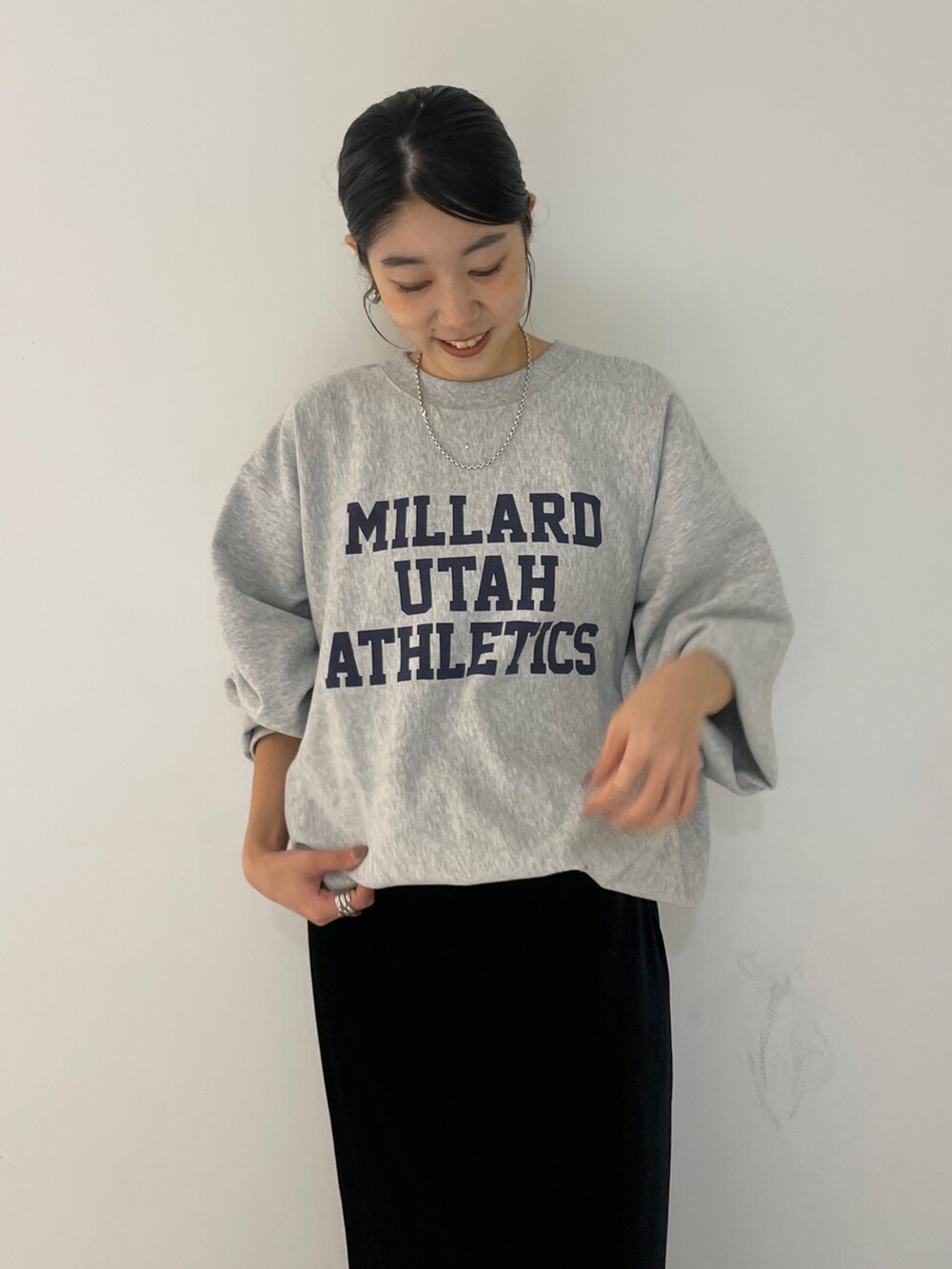 グレー系のスウェット、ブラック系のスカートを着用したレディースの秋コーディネートの5枚目の写真