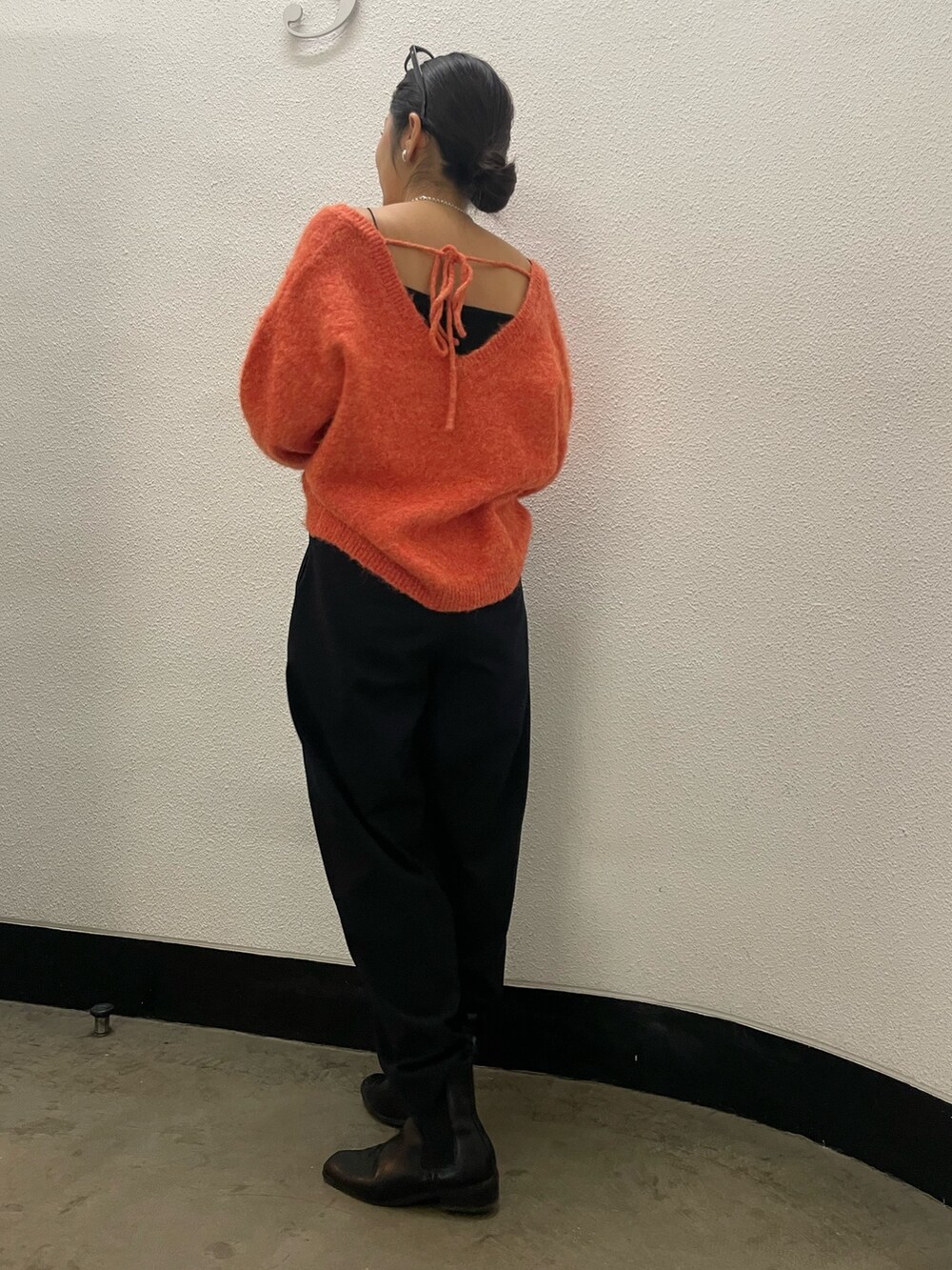 オレンジ系のニット/セーターを着用したレディースの冬コーディネートの2枚目の写真