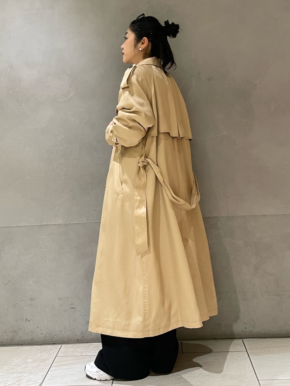 ベージュ系のトレンチコートを着用したレディースの春コーディネートの4枚目の写真