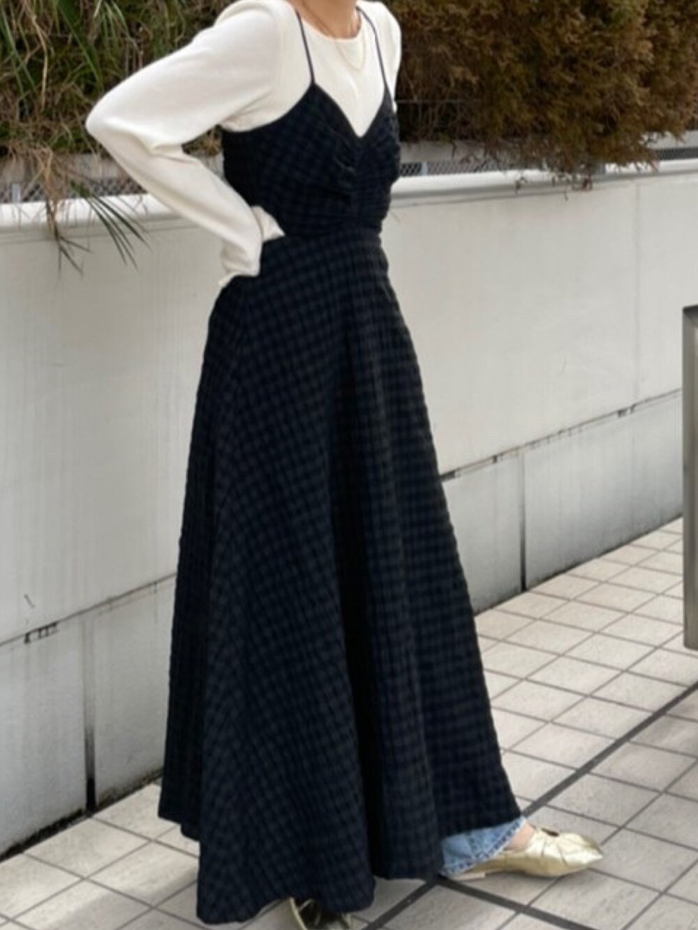 ブラック系のワンピース、ゴールド系のパンプス、ブルー系のデニムパンツを着用したレディースの冬コーディネートの3枚目の写真