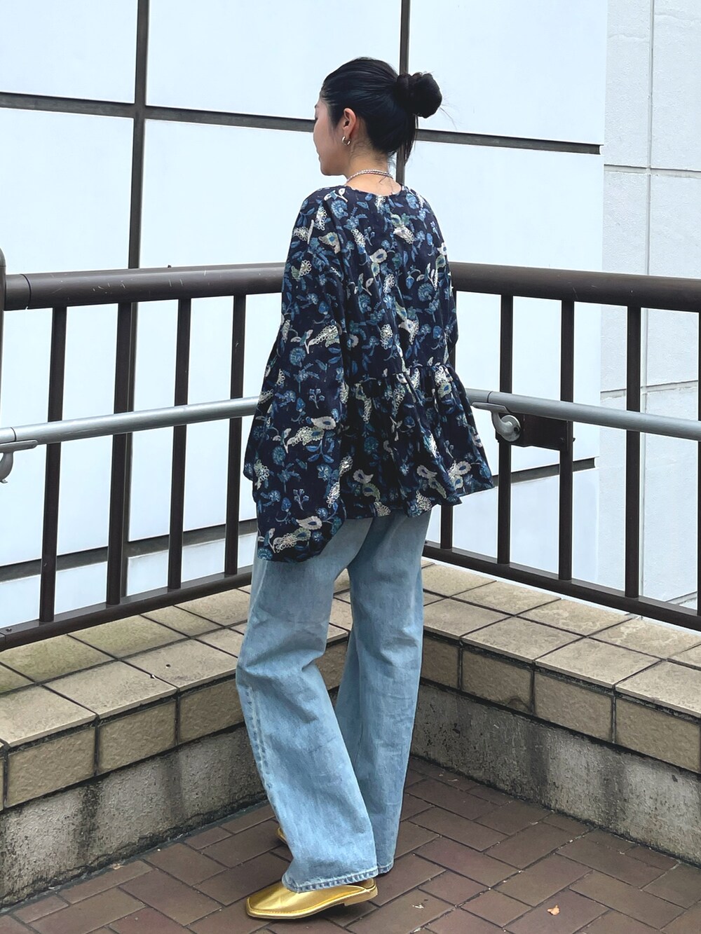 ブルー系のデニムパンツ、ゴールド系のローファー、ブルー系のシャツ/ブラウスを着用したレディースの夏コーディネートの2枚目の写真