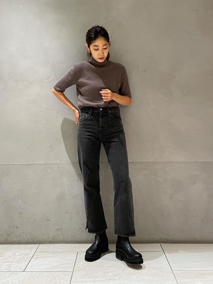 ブラック系のデニムパンツ、ベージュ系のその他アウター、ブラック系のブーツを着用したレディースの秋コーディネートの3枚目の写真