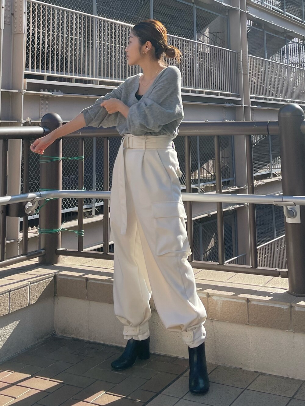 レッド系のニット/セーター、ホワイト系のカーゴパンツを着用したレディースの冬コーディネートの2枚目の写真