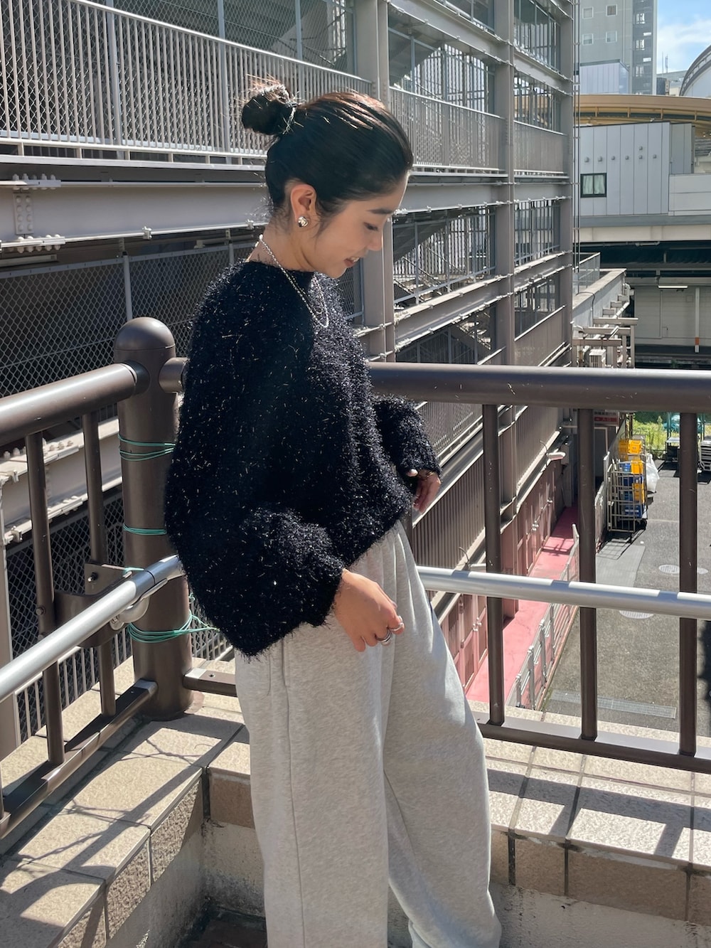 グレー系のスウェットパンツ、ブラック系のニット/セーター、ブラック系のムートンコートを着用したレディースの秋コーディネートの5枚目の写真