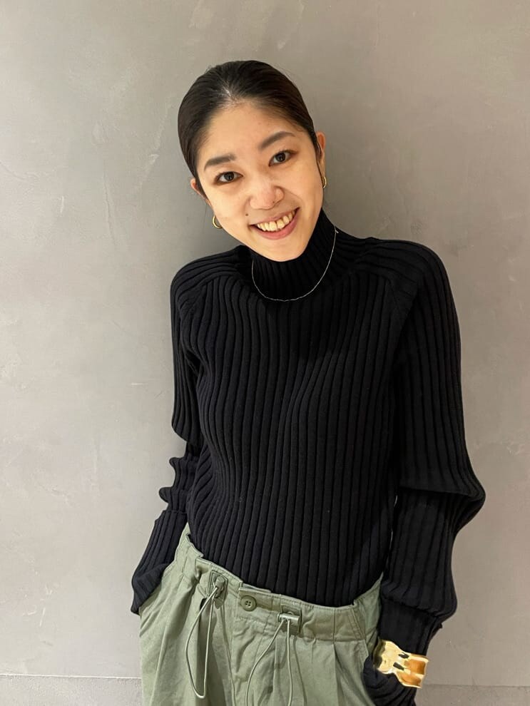 ブラック系のチェスターコート、ベージュ系のその他パンツ、ブラック系のニット/セーターを着用したレディースの秋コーディネートの4枚目の写真