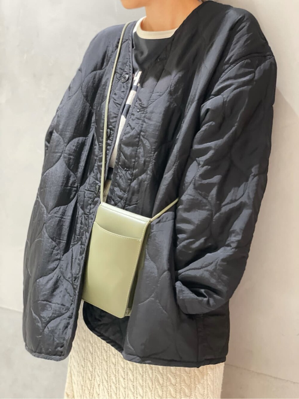 ブラック系のブルゾン、ホワイト系のスカート、グレー系のTシャツ/カットソーを着用したレディースの秋コーディネートの6枚目の写真