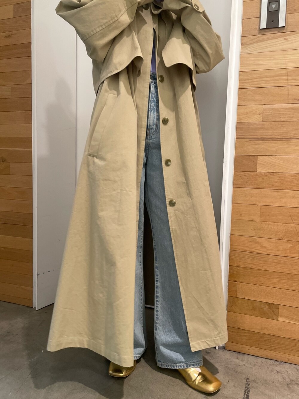 ブルー系のデニムパンツ、ベージュ系のその他アウター、パープル系のTシャツ/カットソーを着用したレディースの冬コーディネートの5枚目の写真