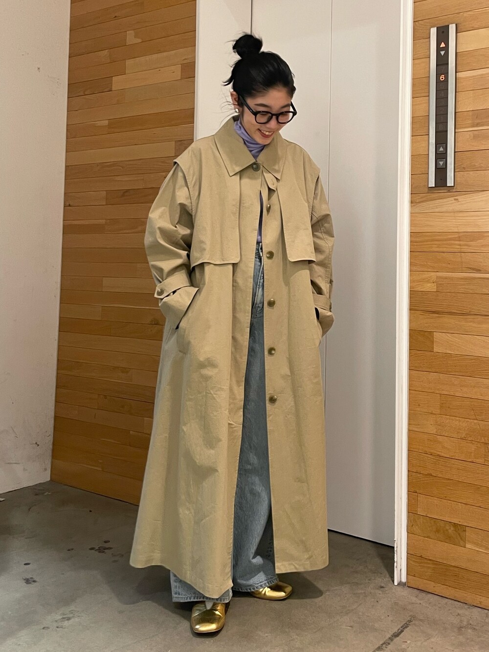 ブルー系のデニムパンツ、ベージュ系のその他アウター、パープル系のTシャツ/カットソーを着用したレディースの冬コーディネートの2枚目の写真