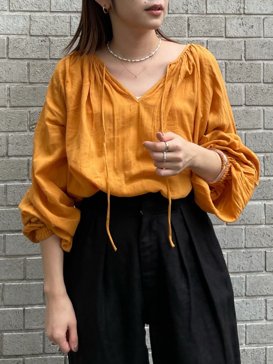 オレンジ系のシャツ/ブラウス、ブラック系のその他パンツを着用したレディースの夏コーディネートの2枚目の写真