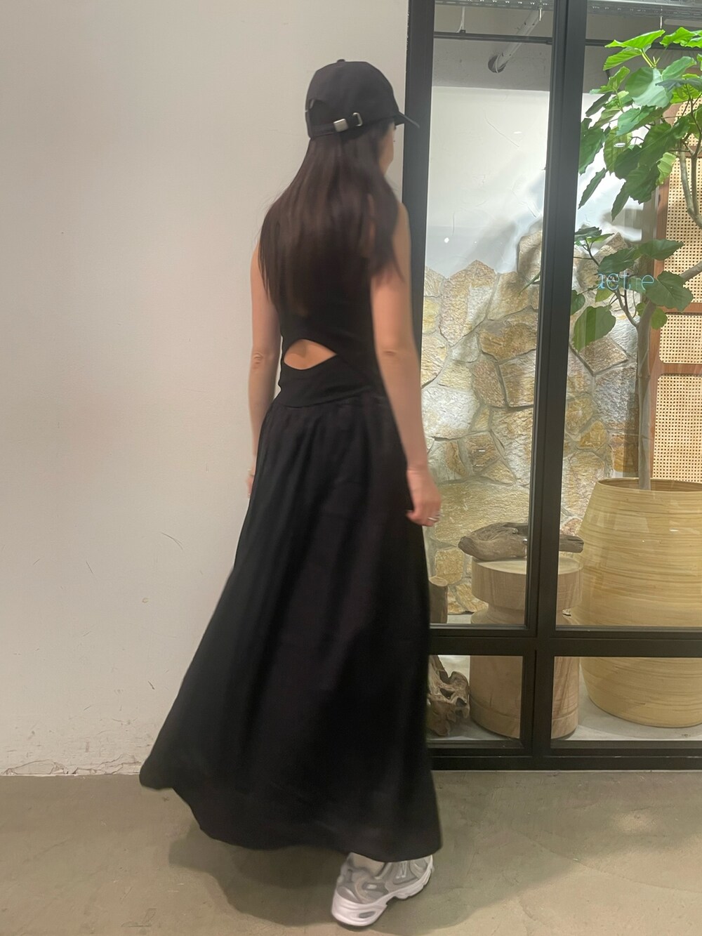 ブラック系のワンピース、グレー系のキャップを着用したレディースの春コーディネートの2枚目の写真