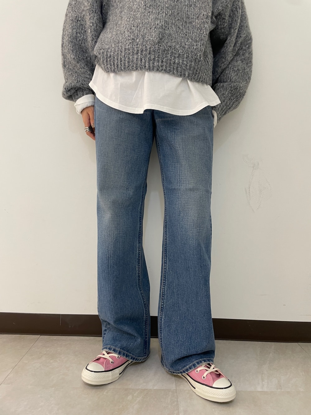 グレー系のニット/セーター、ブルー系のデニムパンツ、ブラック系のブルゾンを着用したレディースの秋コーディネートの7枚目の写真