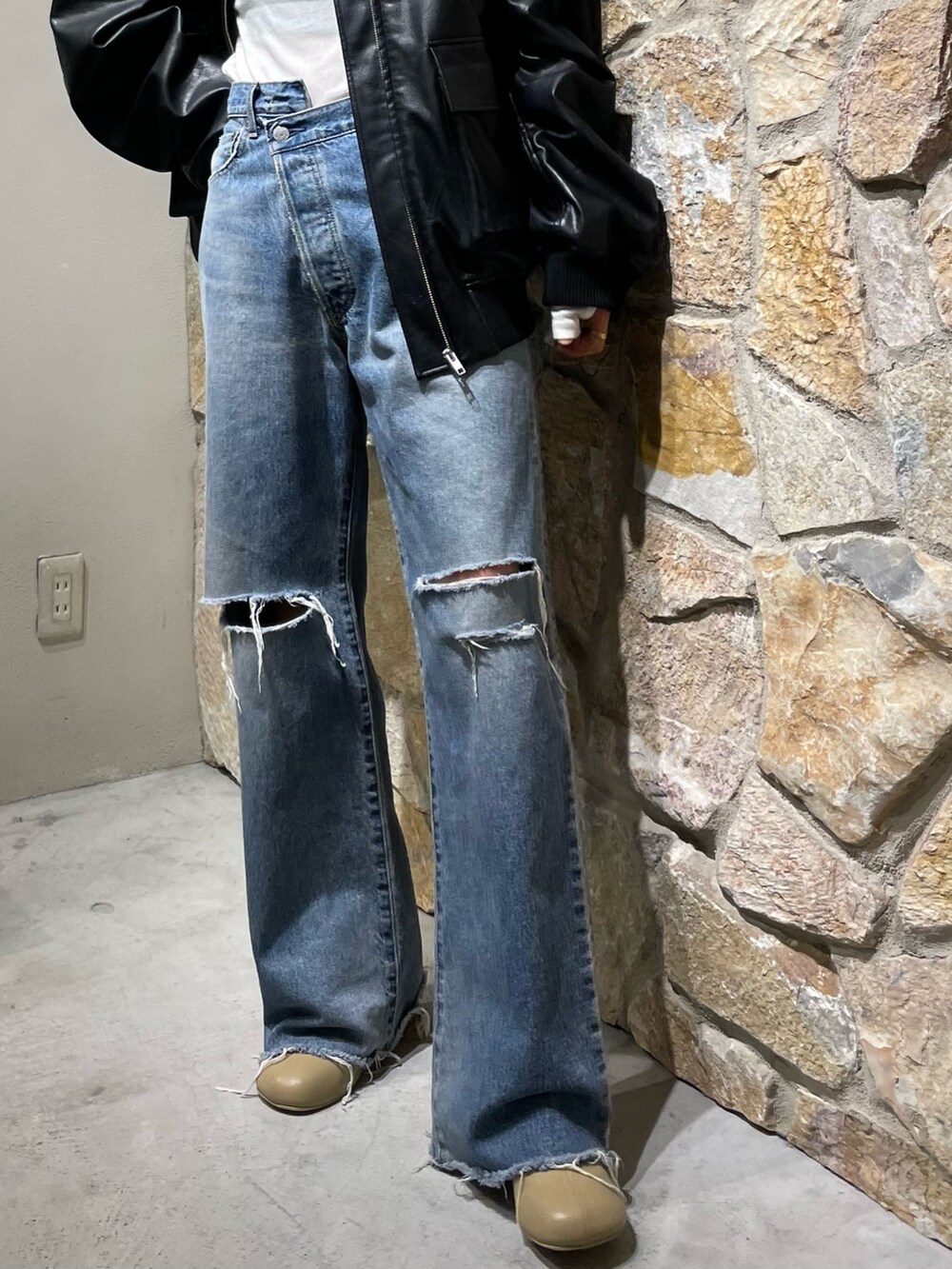 ブルー系のデニムパンツ、ブラック系のブルゾン、ベージュ系のブーツを着用したレディースの秋コーディネートの3枚目の写真