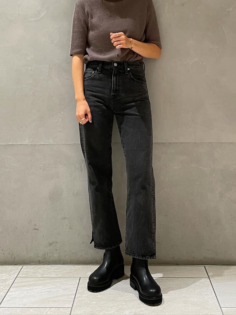 ブラック系のデニムパンツ、ベージュ系のその他アウター、ブラック系のブーツを着用したレディースの秋コーディネートの4枚目の写真