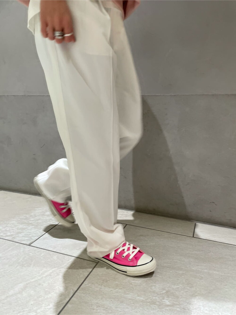 ホワイト系のスラックス、ピンク系のスウェット、ピンク系のスニーカーを着用したレディースの冬コーディネートの4枚目の写真