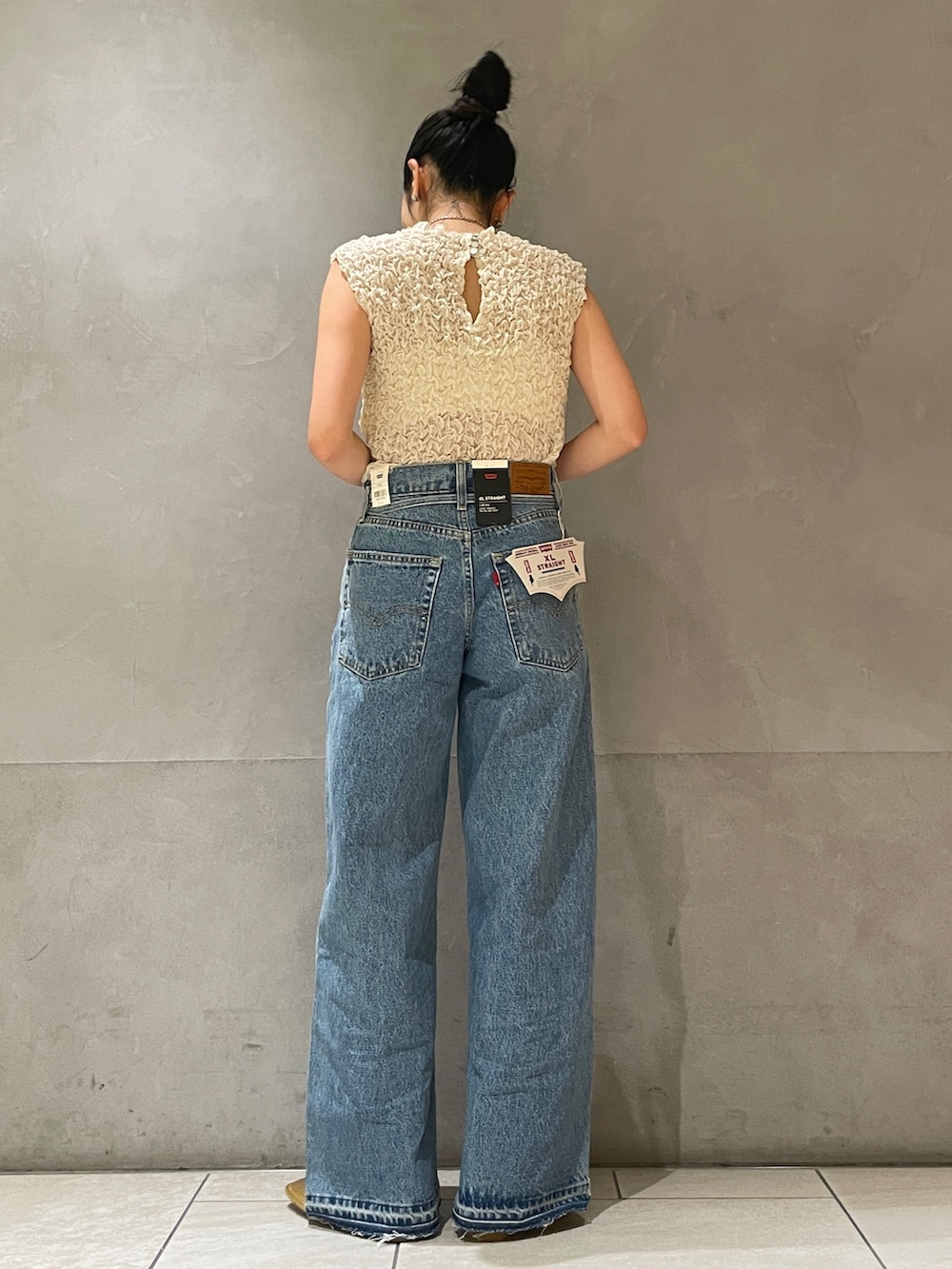 ホワイト系のシャツ/ブラウス、ブルー系のデニムパンツ、ゴールド系のローファーを着用したレディースの夏コーディネートの2枚目の写真