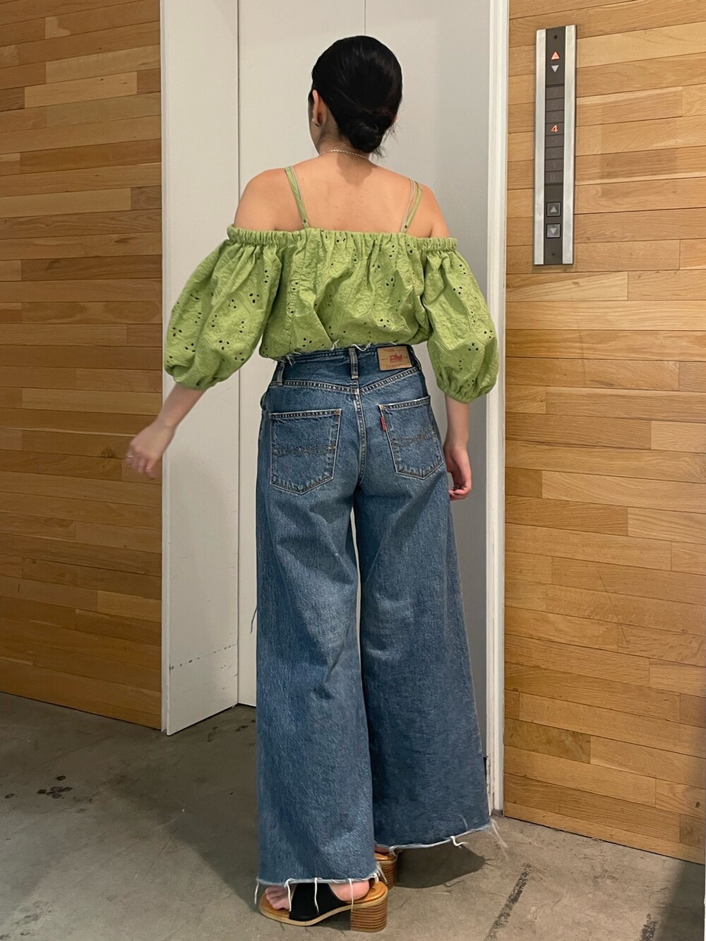 ブルー系のデニムパンツ、ブラック系のサンダル、グリーン系のシャツ/ブラウスを着用したレディースの春コーディネートの3枚目の写真