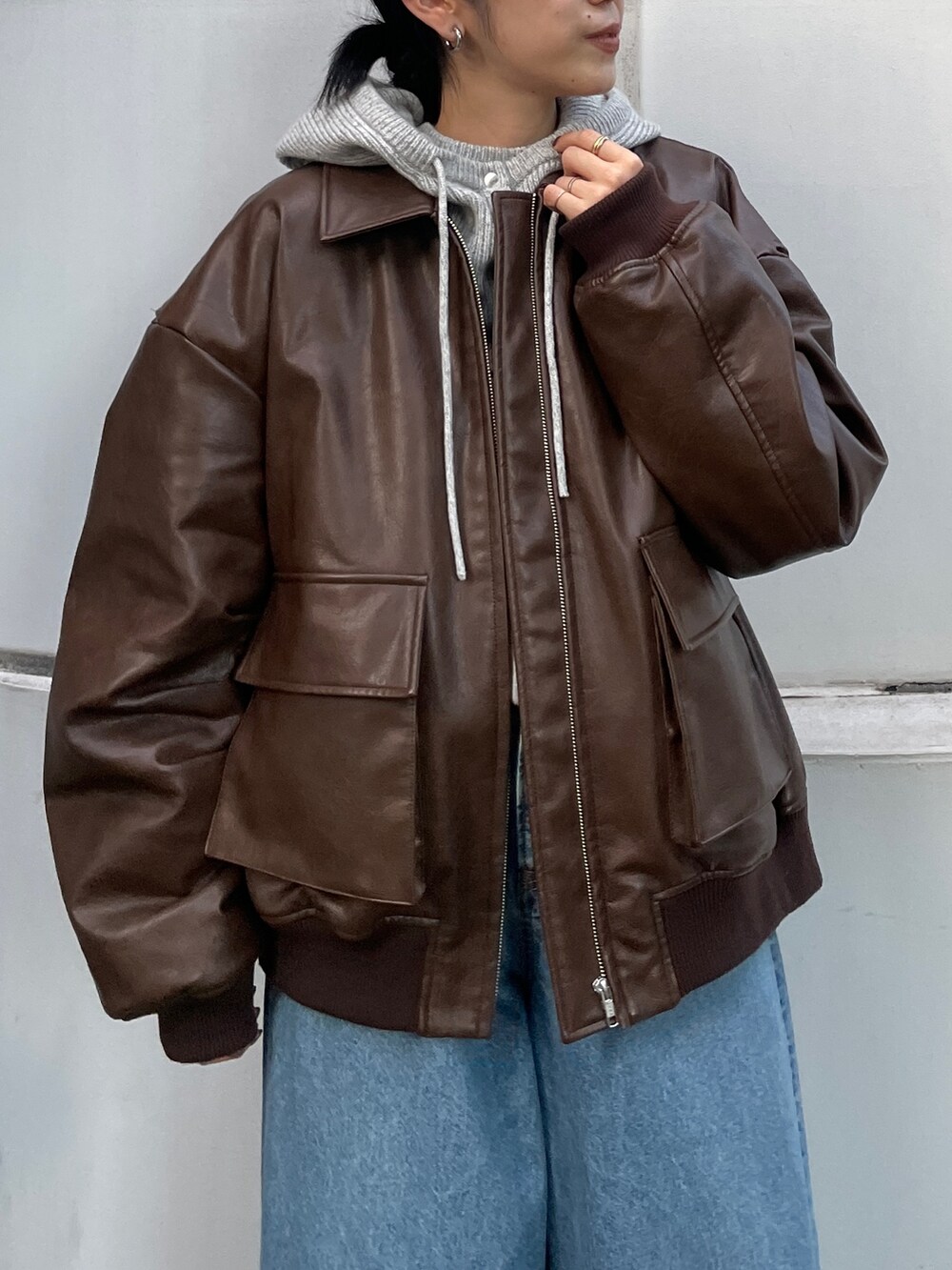 ブルー系のデニムパンツ、ブラウン系のブルゾン、ブラウン系のブーツを着用したレディースの秋コーディネートの5枚目の写真