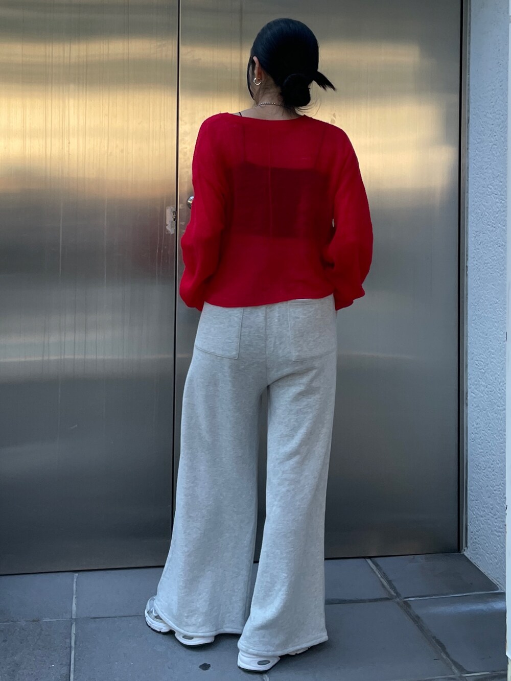 グレー系のスウェットパンツ、レッド系のニット/セーターを着用したレディースの秋コーディネートの5枚目の写真