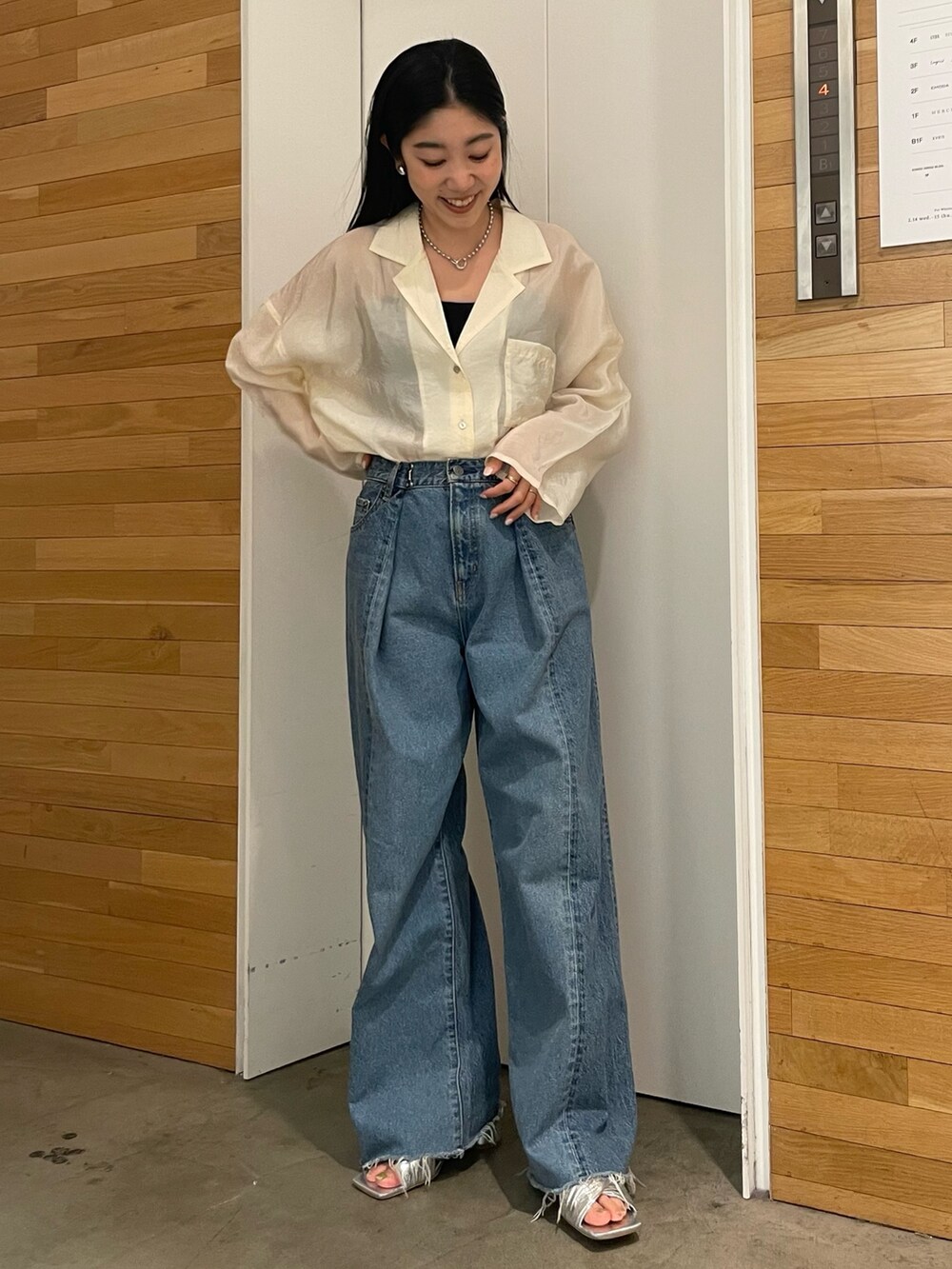 ブルー系のデニムパンツ、ホワイト系のシャツ/ブラウス、シルバー系のサンダルを着用したレディースの春コーディネートの6枚目の写真