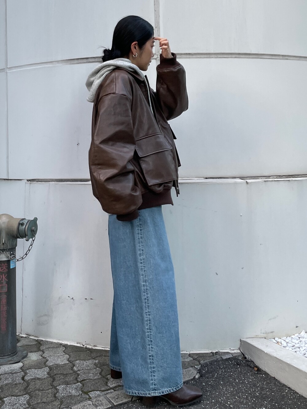 ブルー系のデニムパンツ、ブラウン系のブルゾン、ブラウン系のブーツを着用したレディースの秋コーディネートの3枚目の写真