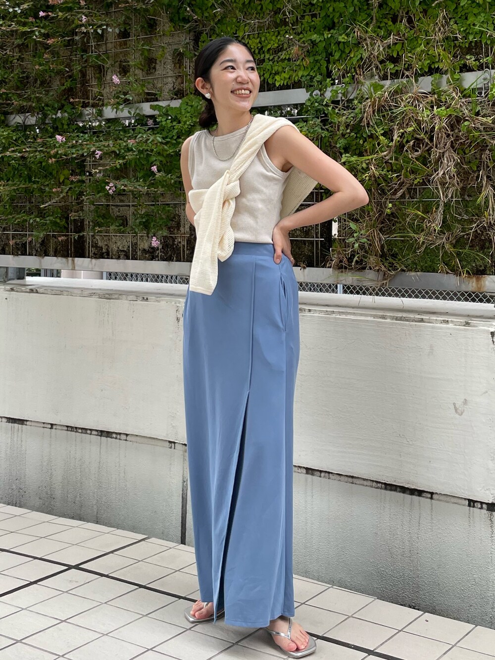 ブルー系のスカート、シルバー系のサンダル、ブラウン系のハンドバッグを着用したレディースの夏コーディネートの3枚目の写真