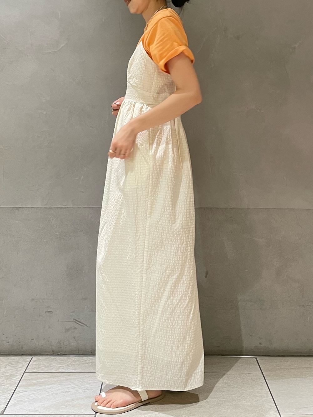 ホワイト系のワンピース、オレンジ系のTシャツ/カットソー、ホワイト系のサンダルを着用したレディースの夏コーディネートの7枚目の写真