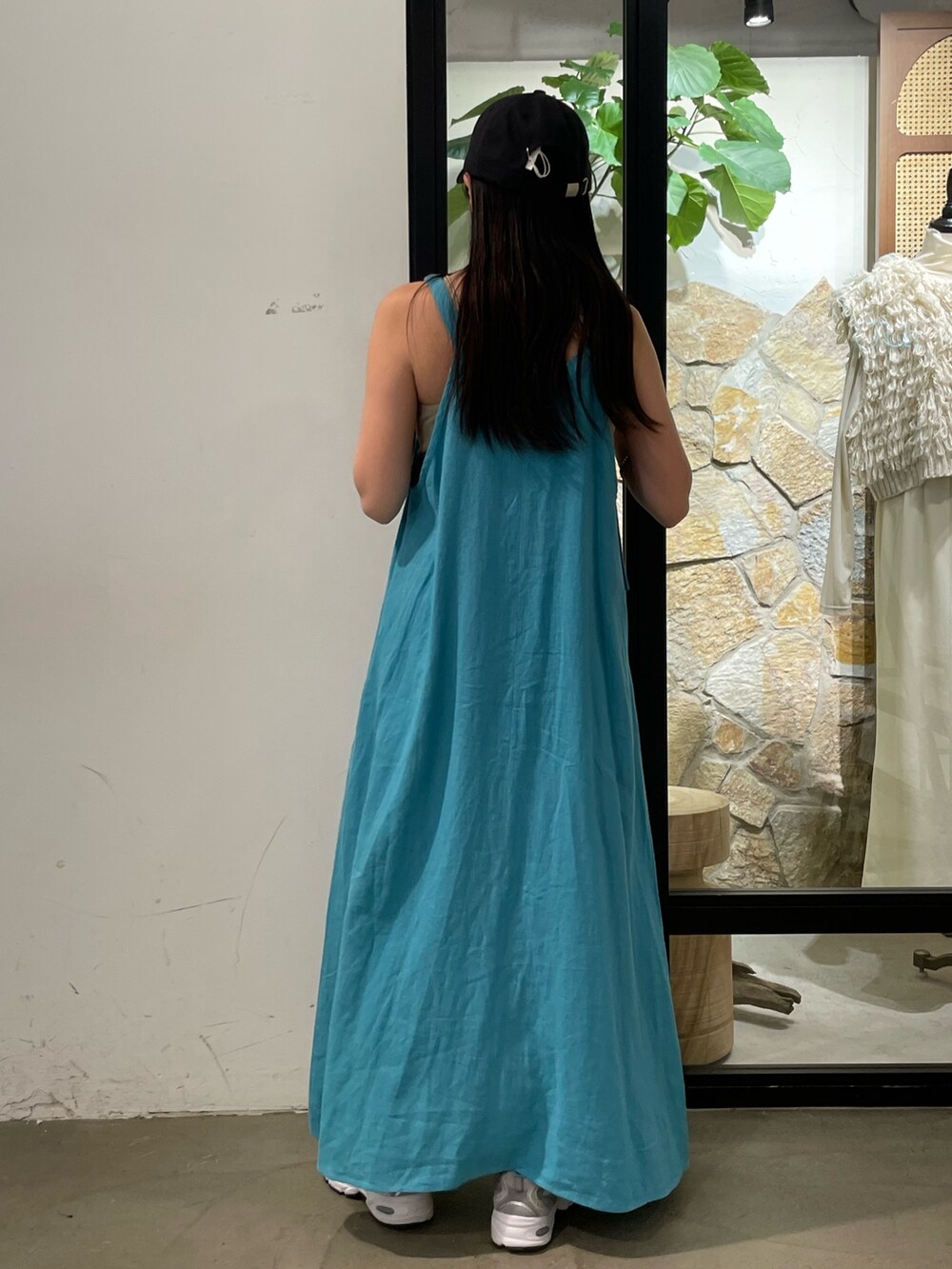 ブルー系のワンピース、グレー系のキャミソール、グレー系のキャップを着用したレディースの夏コーディネートの4枚目の写真