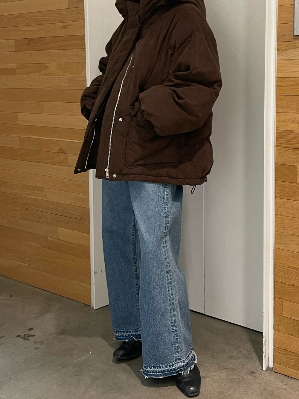 ブラウン系のブルゾン、ブルー系のデニムパンツを着用したレディースの冬コーディネートの4枚目の写真