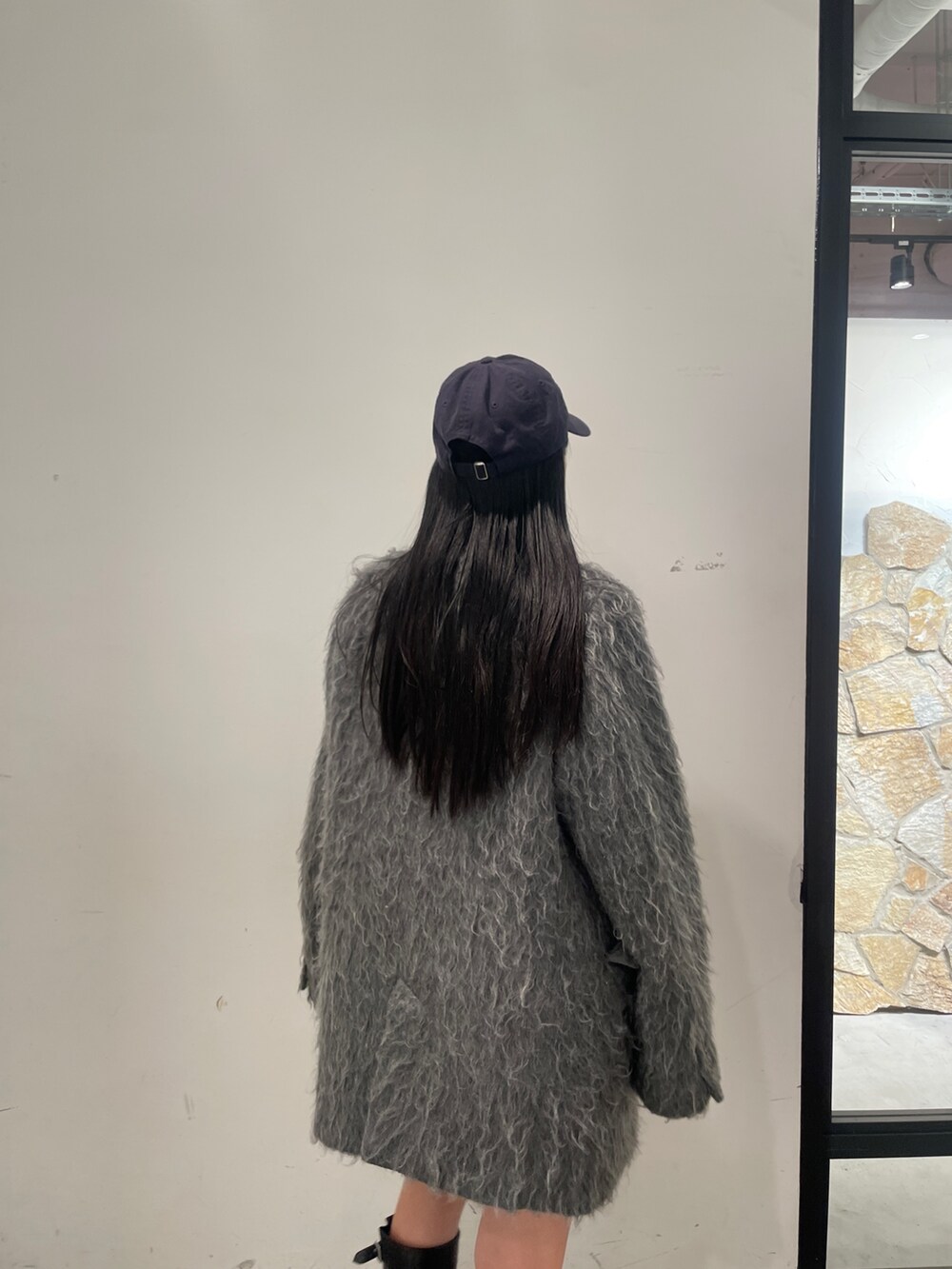 グレー系のテーラードジャケット、ブラック系のブーツ、グレー系のスカートを着用したレディースの秋コーディネートの3枚目の写真