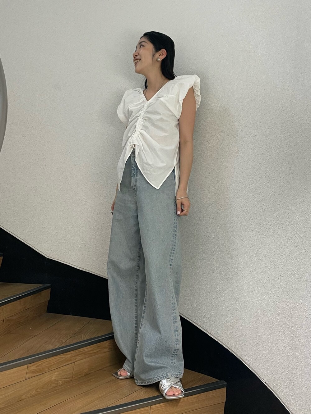 ホワイト系のシャツ/ブラウス、ブルー系のデニムパンツ、シルバー系のサンダルを着用したレディースの春コーディネートの2枚目の写真