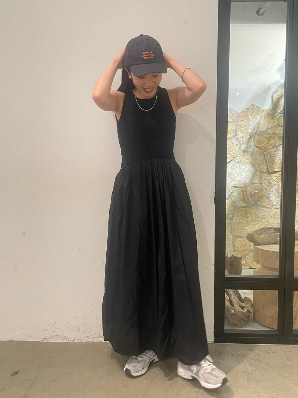 ブラック系のワンピース、グレー系のキャップを着用したレディースの春コーディネートの3枚目の写真