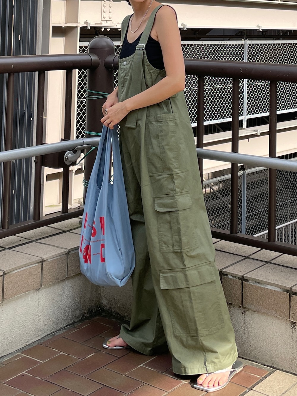グリーン系のサロペット/オーバーオール、ブルー系のエコバッグ/サブバッグ、ブラック系のキャミソールを着用したレディースの夏コーディネートの4枚目の写真