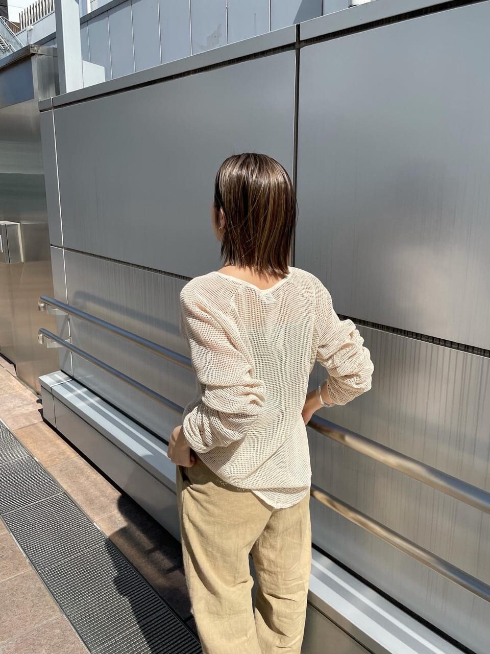 ベージュ系のその他パンツ、ブラック系のサンダル、ホワイト系のTシャツ/カットソーを着用したレディースの春コーディネートの4枚目の写真