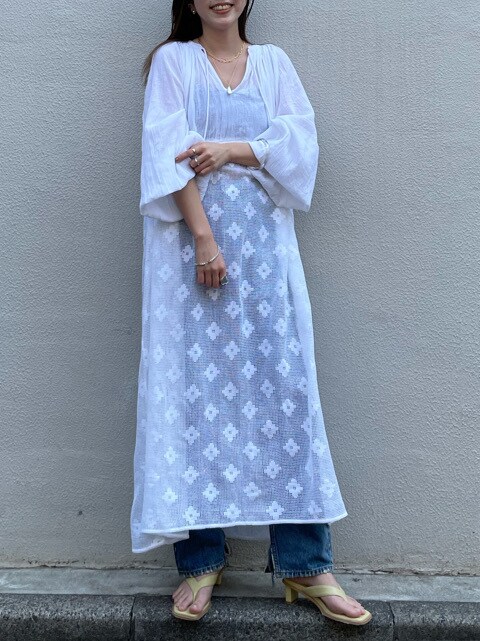 ブルー系のデニムパンツ、グリーン系のサンダルを着用したレディースの春コーディネートの2枚目の写真