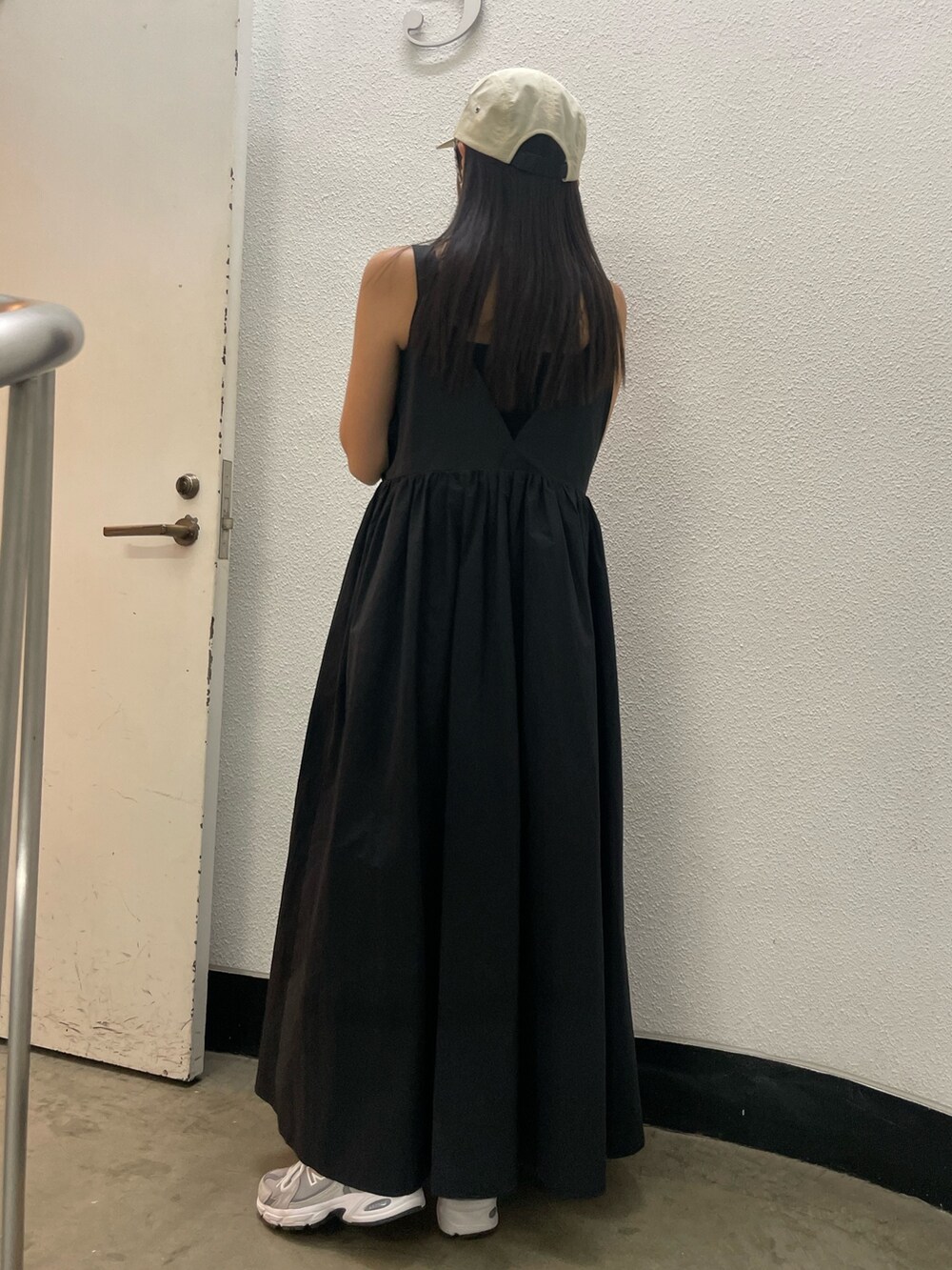 ブラック系のワンピース、ホワイト系のキャップを着用したレディースの春コーディネートの5枚目の写真