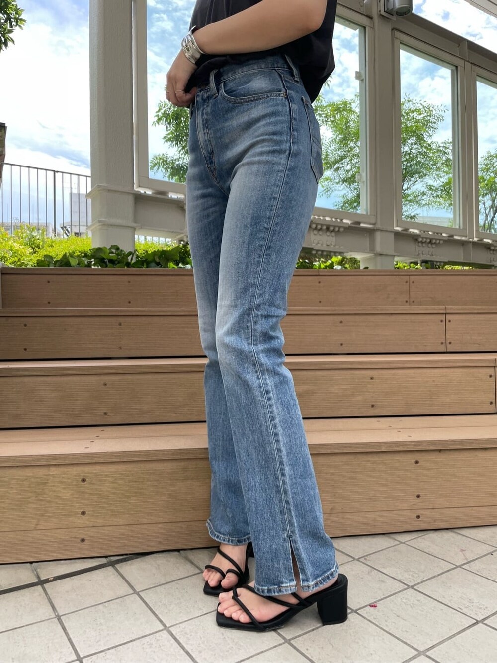 グレー系のタンクトップ、ブルー系のデニムパンツを着用したレディースの夏コーディネートの5枚目の写真