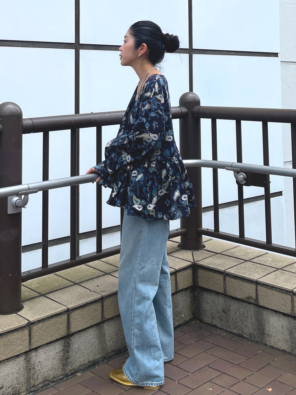 ブルー系のデニムパンツ、ゴールド系のローファー、ブルー系のシャツ/ブラウスを着用したレディースの夏コーディネートの4枚目の写真