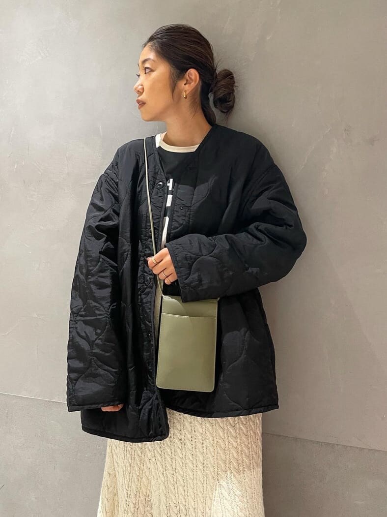 ブラック系のブルゾン、ホワイト系のスカート、グレー系のTシャツ/カットソーを着用したレディースの秋コーディネートの2枚目の写真