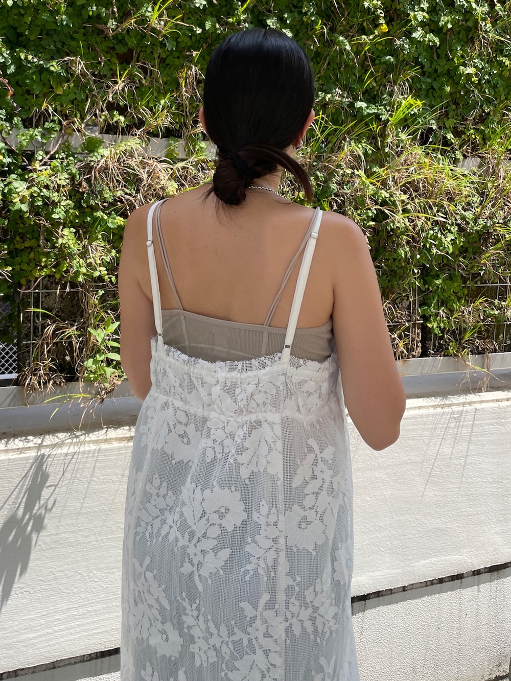 ホワイト系のワンピース、グレー系のキャミソール、ブルー系のデニムパンツを着用したレディースの夏コーディネートの5枚目の写真