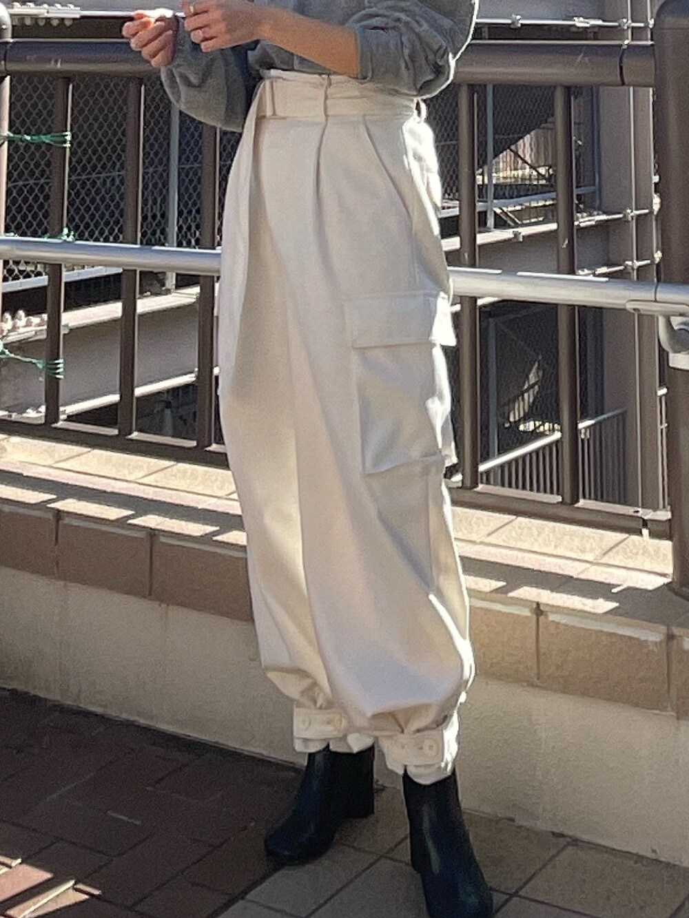 レッド系のニット/セーター、ホワイト系のカーゴパンツを着用したレディースの冬コーディネートの5枚目の写真